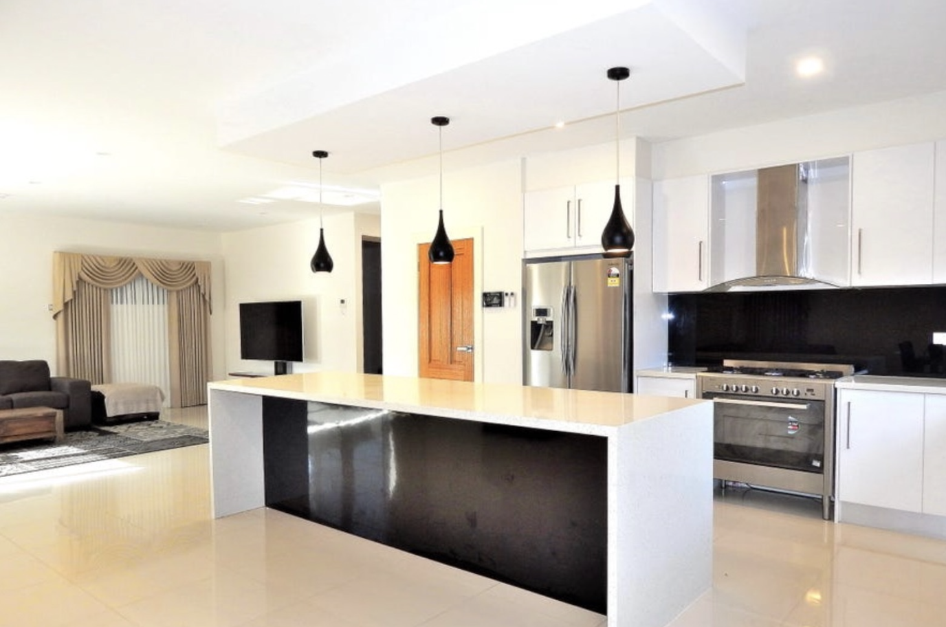Bright open-plan kitchen and living area with island bench and quality appliances